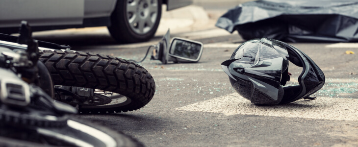 Motorcycle and motorcycle helmet laid out on the road after an accident with a car