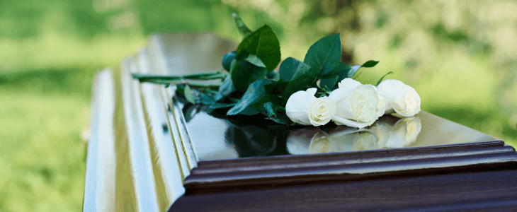 White rose on a brown casket to represent death