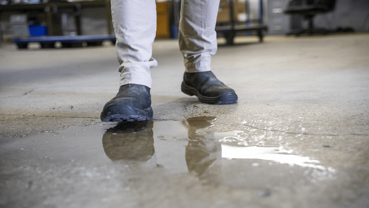 Man walking over a small puddle while at work